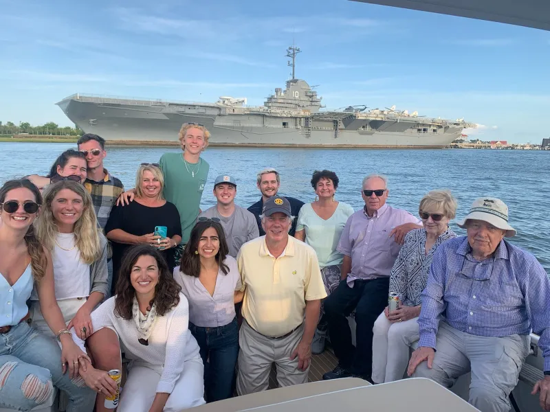 a group of people posing for a photo by the USS Yorktown CV-10