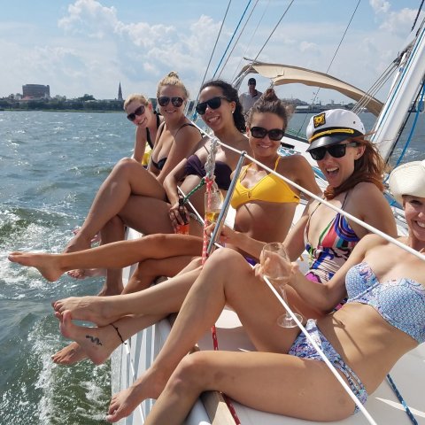 a group of women sitting on a boat in a body of water