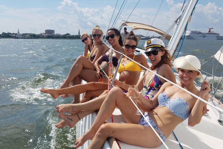 a group of women sitting on a boat in a body of water