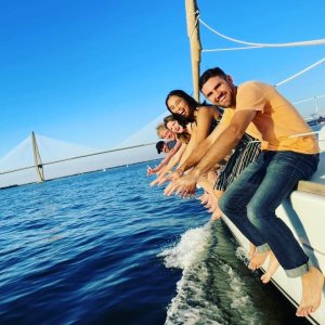 a group of people riding on the back of a boat in the water