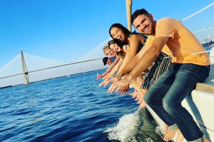 a group of people riding on the back of a boat in the water