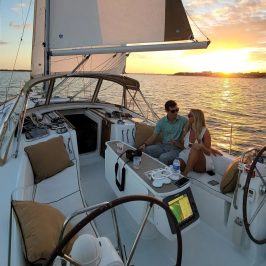 a couple on a sailboat at sunset