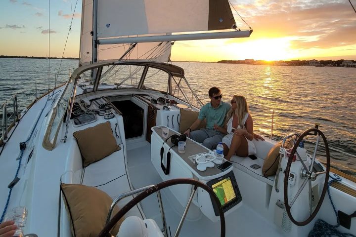 a couple on a sailboat at sunset