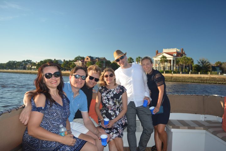 a group of people posing for a picture next to a body of water