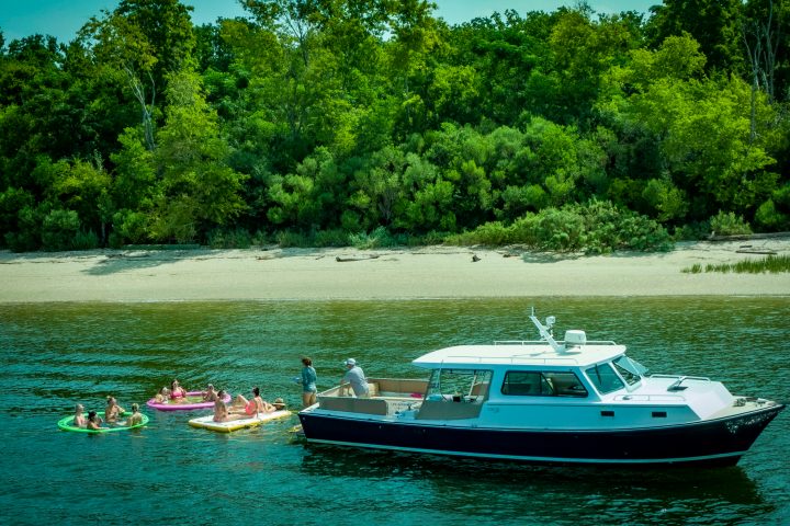 a boat floating along a river next to a body of water