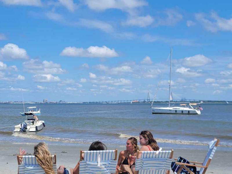 a group of people on a beach near a body of water
