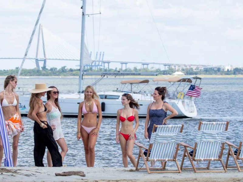 a group of people standing next to a body of water