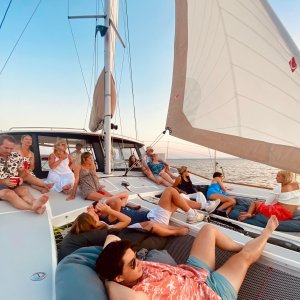 bachelorette party relaxing on a sailboat deck at sunset.