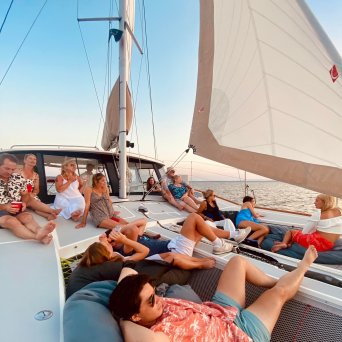bachelorette party relaxing on a sailboat deck at sunset.