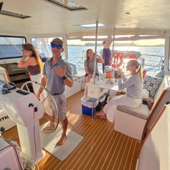 Group of people relaxing on a boat with sunset view.