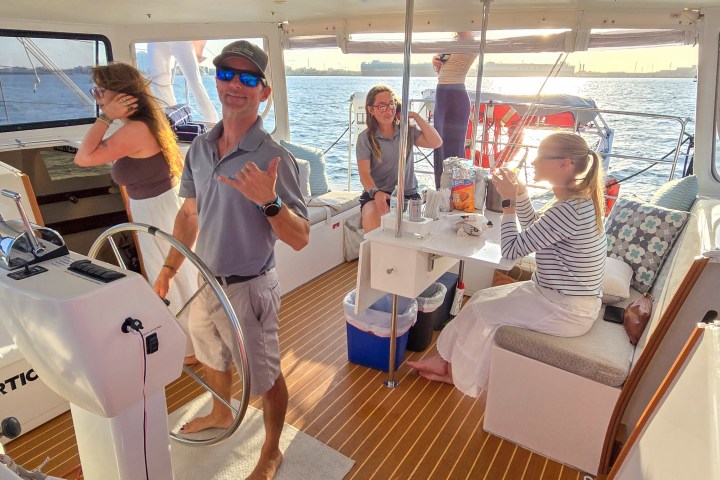 Group of people relaxing on a boat with sunset view.