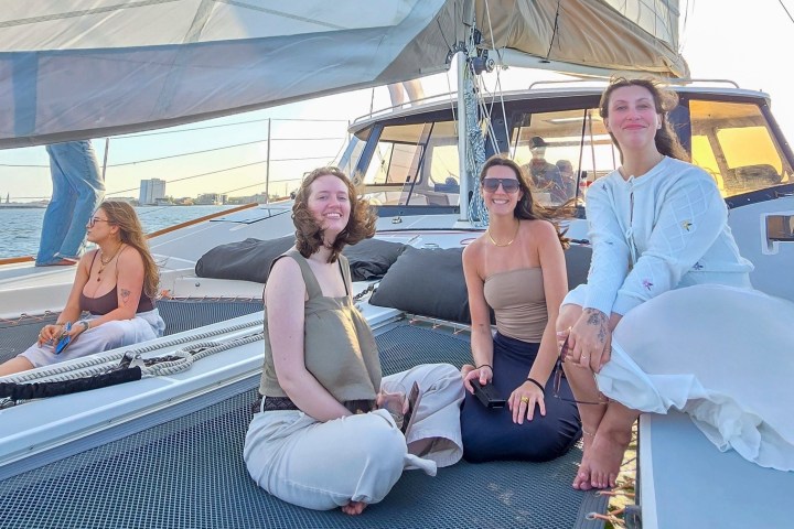 Group of people sitting on a boat deck enjoying a sunny day.